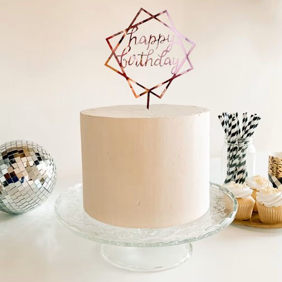 gâteau d'anniversaire simple avec deco gateau "Happy Birthday", accompagné de cupcakes et d'une boule à facettes