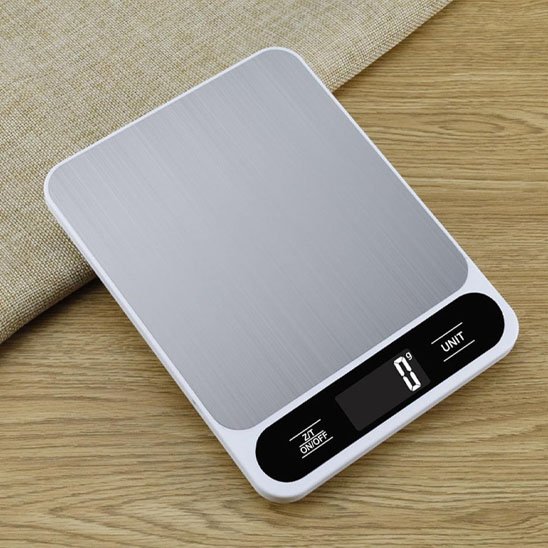 Balances de cuisine avec balance vide sur fond bois