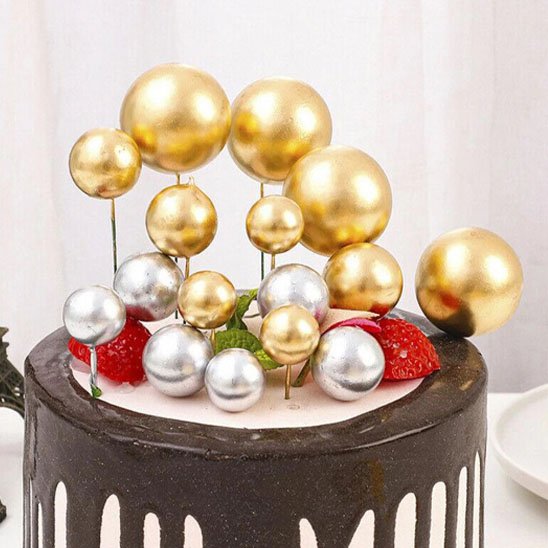 Decoration gâteau avec boules dorées et argentées sur crème 