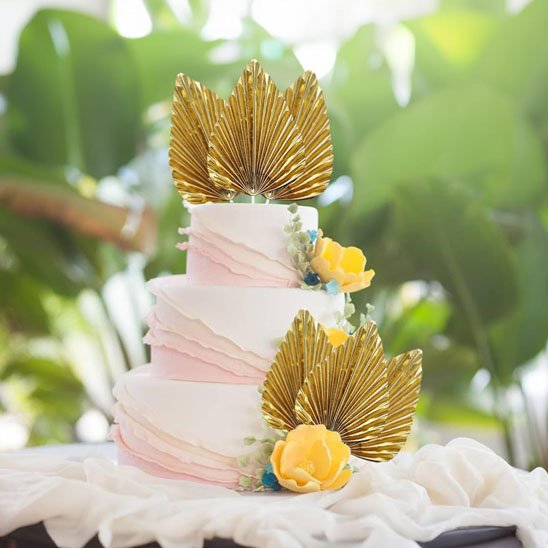 Decoration gateau avec éventails dorés et fleurs jaunes sur gâteau trois étages