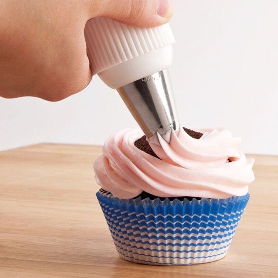 Douille patisserie appliquant crème rose sur cupcake