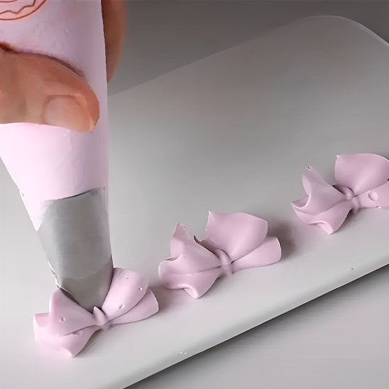 Douille pâtisserie appliquant une décoration rose en forme de nœud