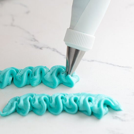 Douille patisserie formant des vagues avec crème bleue