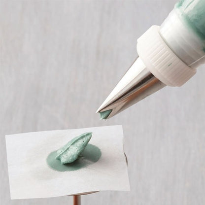 Douille pâtisserie formant une pointe verte sur papier