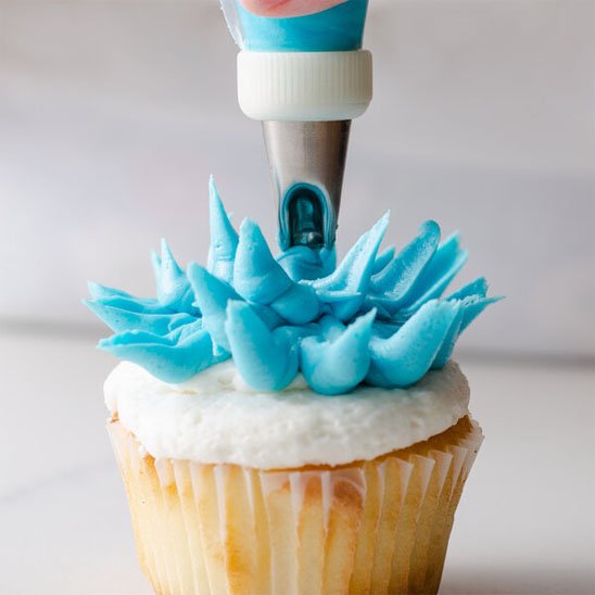 Douille patisserie utilisée pour décorer un cupcake avec crème bleue