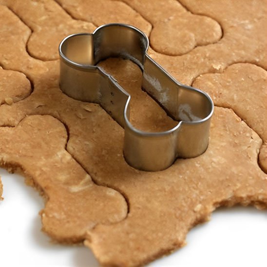 Emporte pièce en forme d'os découpant des biscuits en pâte