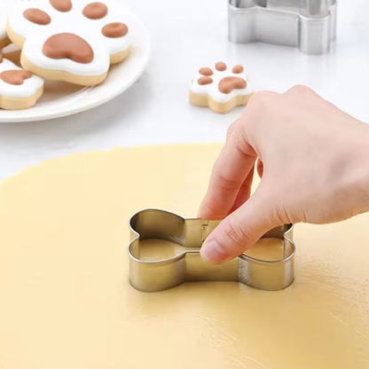 Emporte pièce en forme d'os découpant la pâte avec la main