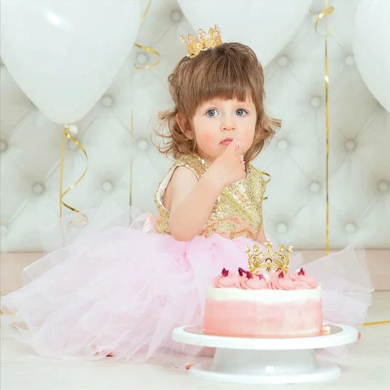  Enfant avec couronne decoration gateau et gâteau rose décoré, ballons