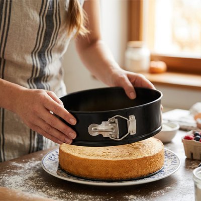 Femme retirant un gâteau du Moule a manqué après cuisson