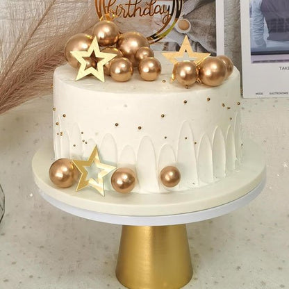 Gâteau d'anniversaire décoré de boules dorées et étoiles