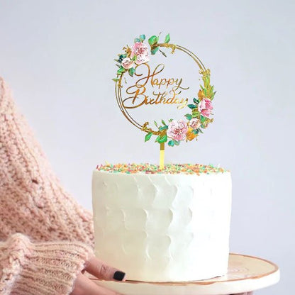 gâteau d'anniversaire décoré de perles colorées, avec un deco gateau "Happy Birthday" et une personne tenant le gâteau