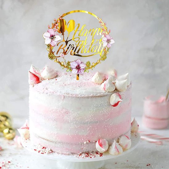 gâteau d'anniversaire rose décoré avec deco gateau floral "Happy Birthday" et des meringues sur le dessus