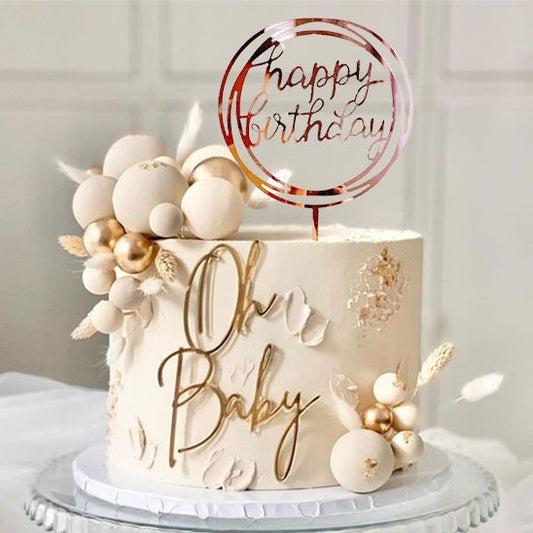 gâteau de fête décoré avec des ballons dorés, des éléments floraux et deco gateau  "Happy Birthday" au-dessus de l'inscription "Oh Baby"