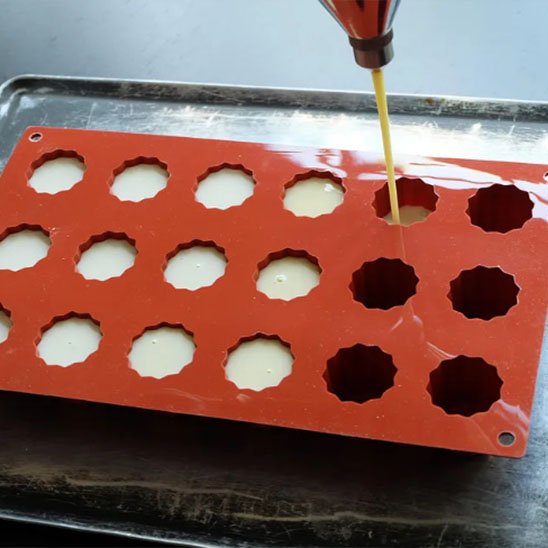 Moules en silicone​ cannelés remplis de préparation pâtissière