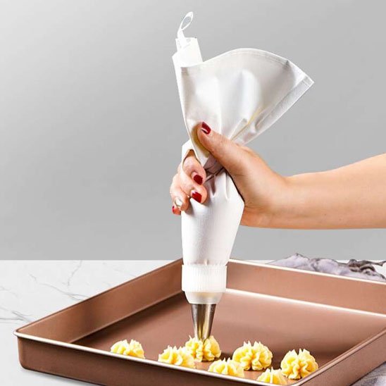 Poche à douille décorant des biscuits avec de la crème