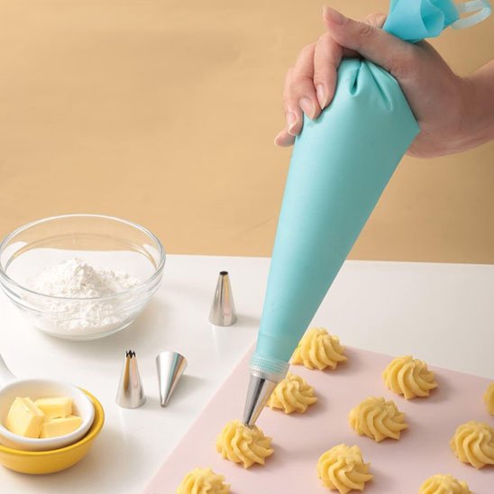 Poche à douille décorant des biscuits sur une plaque