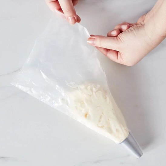 Poche à douille remplie de crème pour la décoration de gâteau