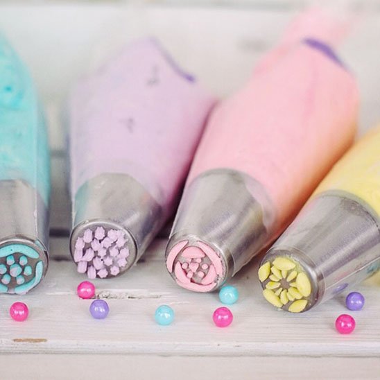 quatre poche à douille posés sur une table avec différentes couleurs et motifs 