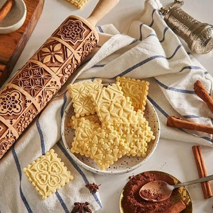 rouleau à pâtisserie décoratif utilisé pour imprimer des motifs sur des biscuits fraîchement coupés, entourés de cannelle et d'épices