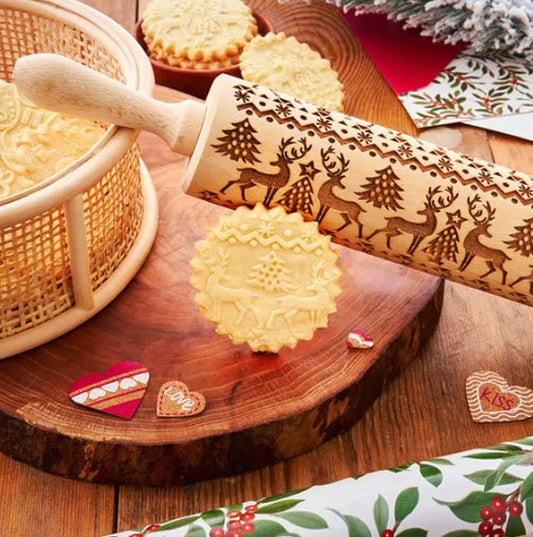 rouleau à pâtisserie en bois décoré de rennes et sapins, avec des biscuits festifs et des décorations de Noël